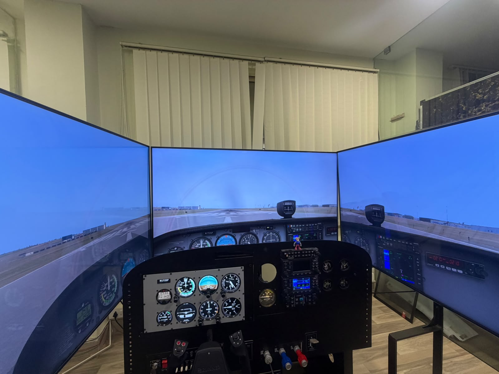 Skylink flight simulator with three wraparound displays and physical cockpit controls